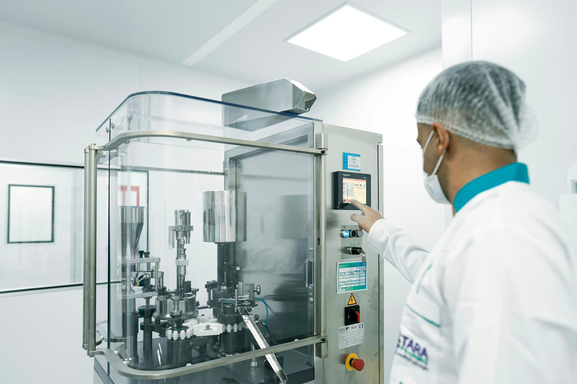 Operator at a pharmaceutical capsule-filling line in a cleanroom